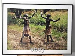 Tribu africaine Omo, 23 photographies encadrées, 2 jeunes femmes dansent et se donnent la main haut, Sud-Ouest de l'Éthiopie.